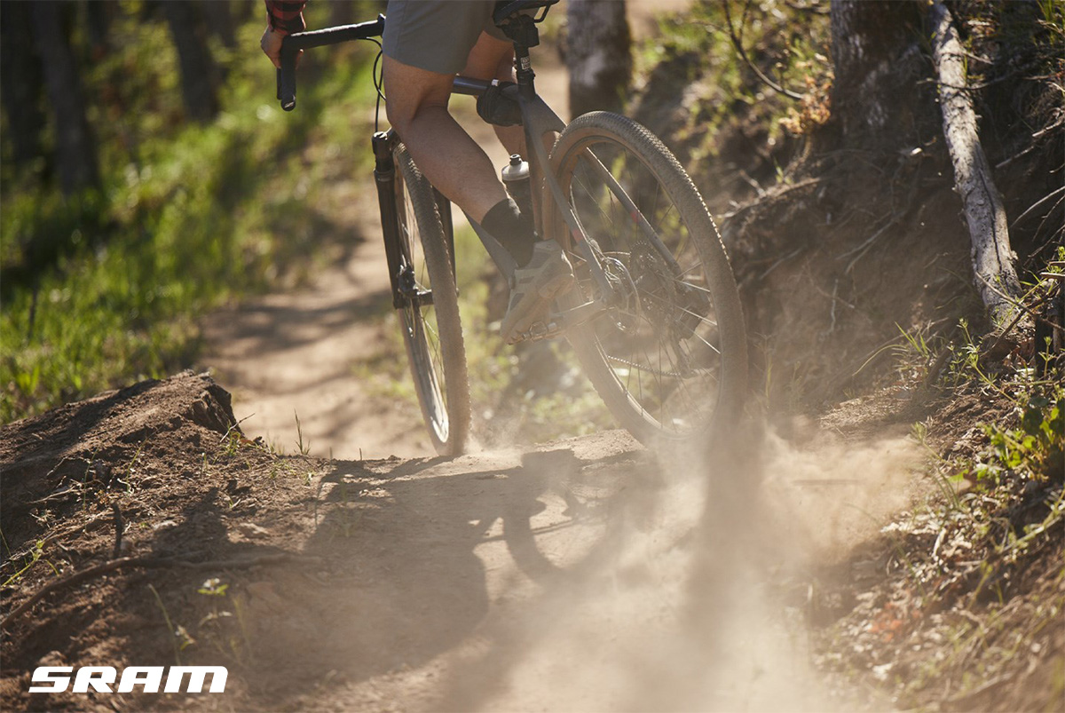 Un ciclista pedala su uno sterrato con una bici gravel che monta i nuovi componenti Sram della linea XPLR